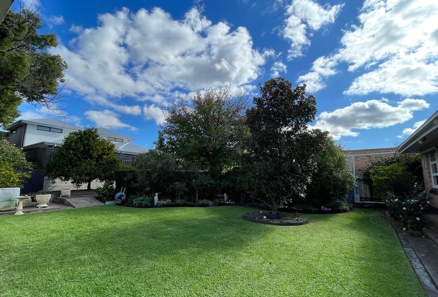 Wide backyard lawn and established garden beds after a maintenance visit in Klemzig, Adelaide