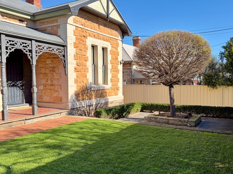 Clipped hedging and tidy lawn at a sandstone villa in Prospect, Adelaide